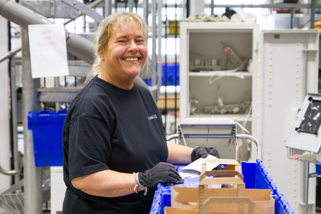 Kvinna i Samhall-t-shirt. Ler och tittar in i kameran.