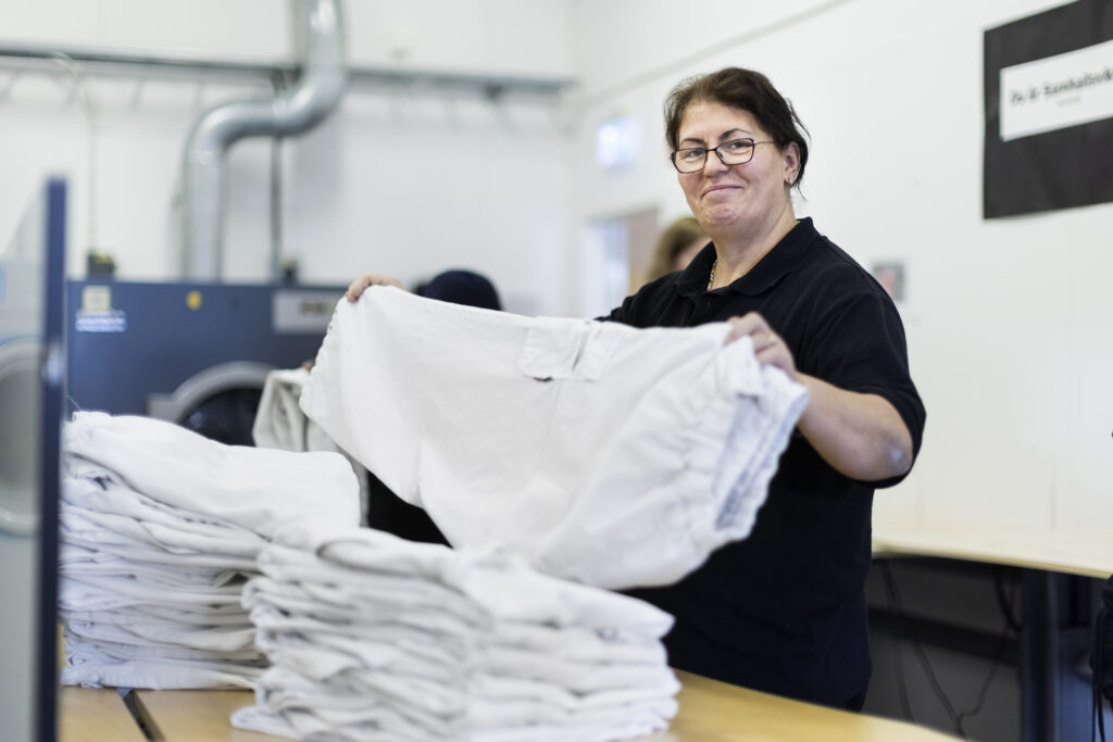 Kvinna som arbetar på tvätteri.