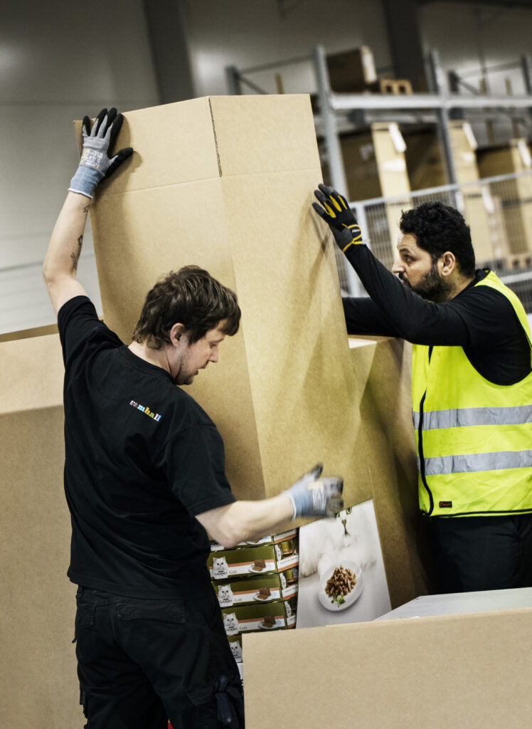 Två män hjälps åt att lyfta en stor låda.