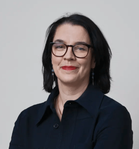 Samhalls vd Sara Revell Ford ler och tittar in i kameran. Hon har utsläppt mörkt hår, glasögon med mörka bågar och bär en svart blus.