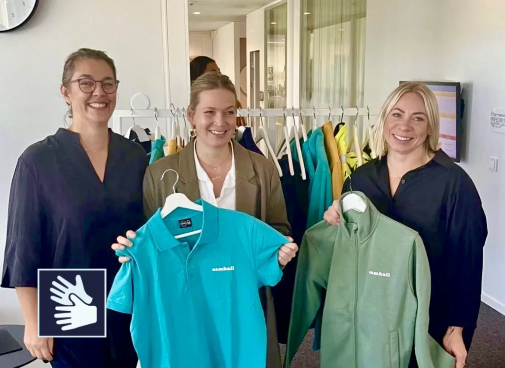 Tre personer som visar Samhalls nya arbetskläder.