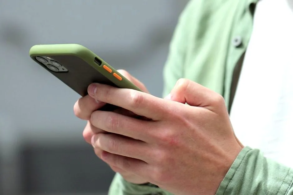 En person som håller i en mobil.