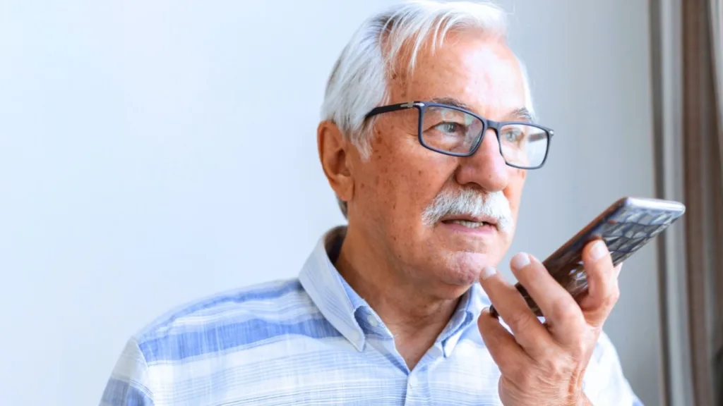 Äldre man i grått hår och glasögon. Han talar i mobilen.