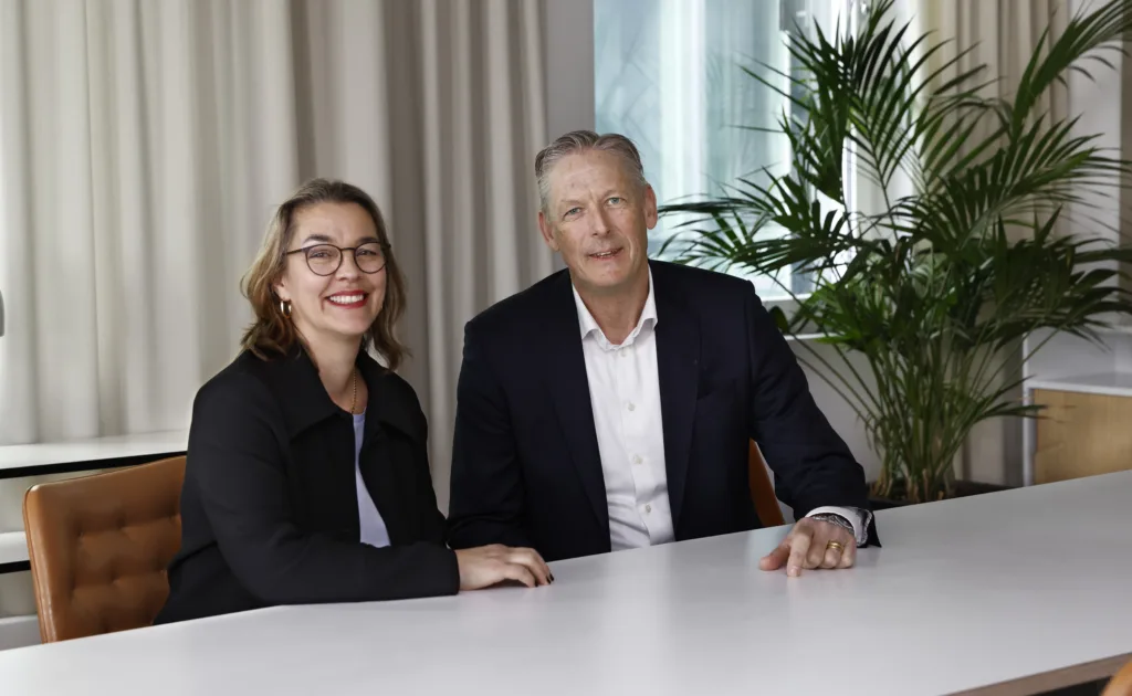 Samhalls vd Sara Revell Ford och Per Spåls, vd för Vattenfall Business Services Nordic. De sitter bredvid varandra vid ett konferensbord. Båda ler och tittar in i kameran. Båda bär mörk kavaj. Sara har glasögon med mörka bågar. 