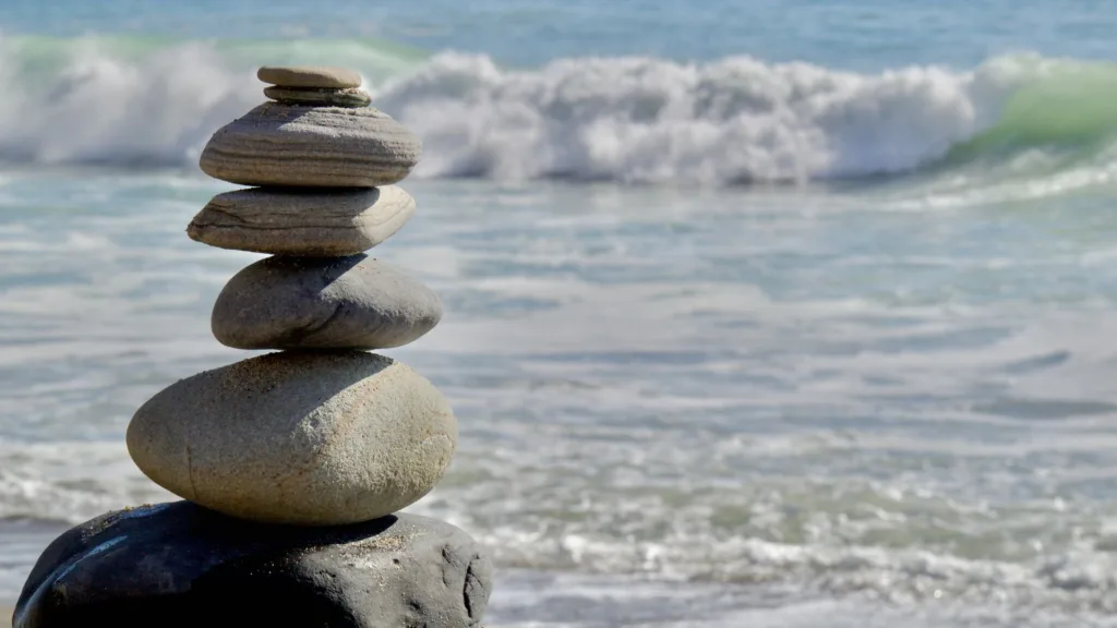 Stenar staplade på varandra, havet i bakgrunden.