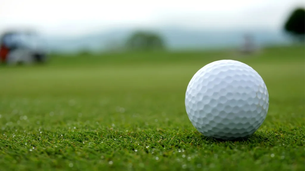 En inzoomad golfboll på en golfbana.