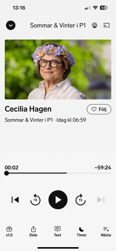 Sveriges Radios mobilapp i läget där man aktiverar textfunktionen för programmet Sommar i P1. Det valda programmet är journalisten Cecilia Hagens sommarprat den 10 juli 2025. Appen visar även en porträttbild av henne. Cecilia har brunt hår med gyllene slingor. Håret ramar in ansiktet och slutar ungefär vid hakan. Cecilia har ljus hy och blå ögon och hon bär runda glasögon med ganska tjocka bågar i svart och brunt. Hon bär en skjorta som är öppen i halsen och ser ut att kunna vara i linne. Den är bredrandig på längden, i vitt och beige. En vit topp skymtar undertill. Och i öronen skymtar en silverpärla. Cecilias blomsterkrans går i gult och ljust lila. Hon är 79 år.