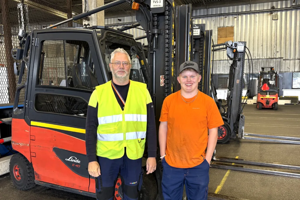 Gustav och Stefan på Volvo. De står bredvid varandra framför några truckar.