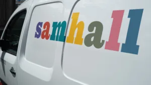 Vit Samhallbil med loggan på sidan.